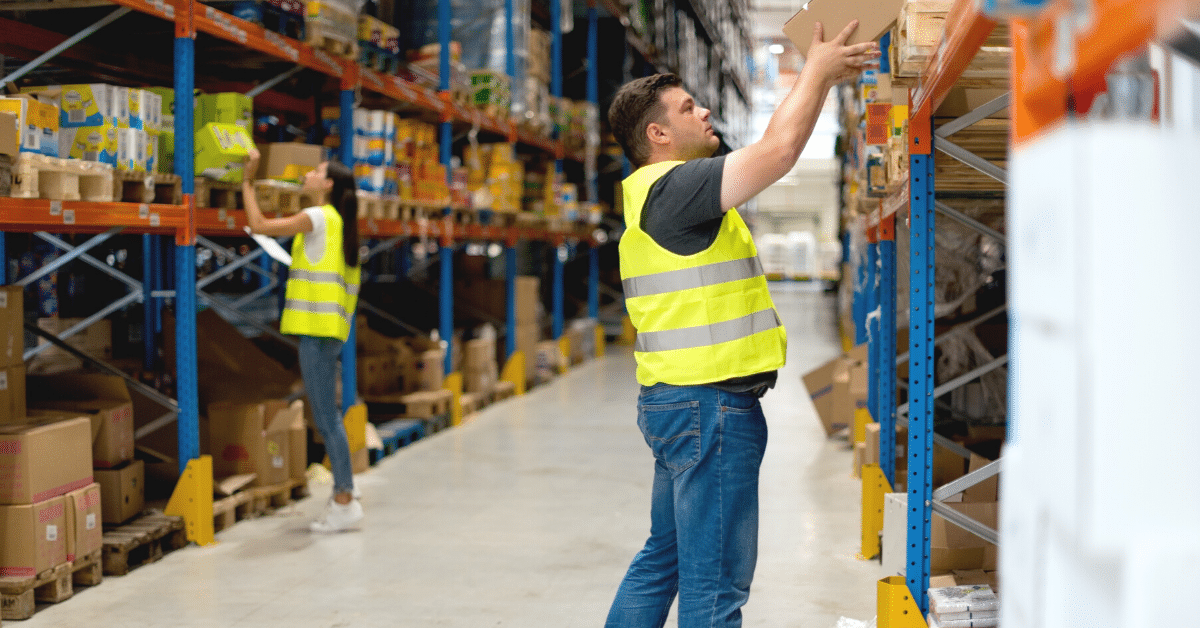 Warehouse worker putting a box on a shelf
