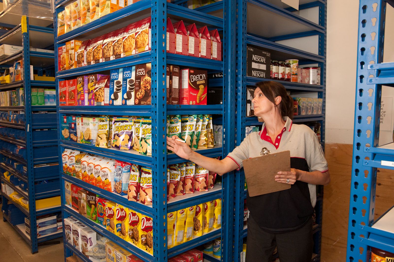 Female inspecting shelves in the storage room for safety. Workplace inspection training.
