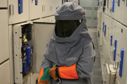 A welder putting on personal protective equipment