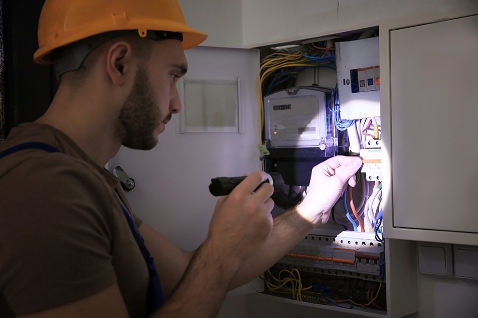 Worker examining an electrical panel