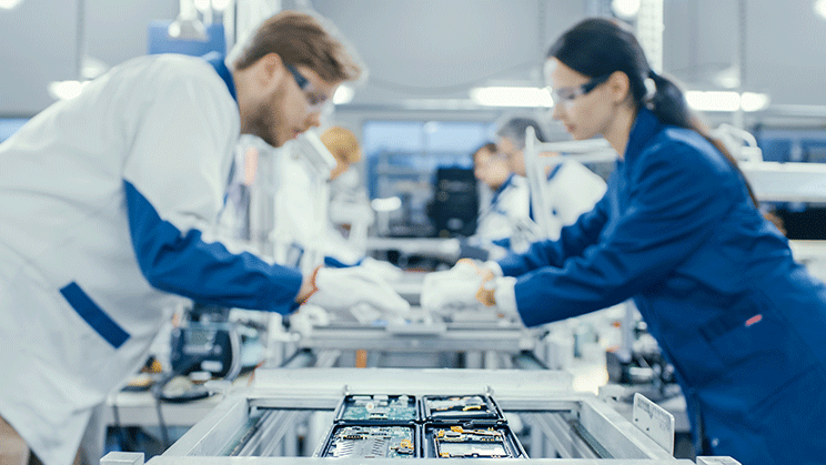 Man and woman leaning over assembly line working
