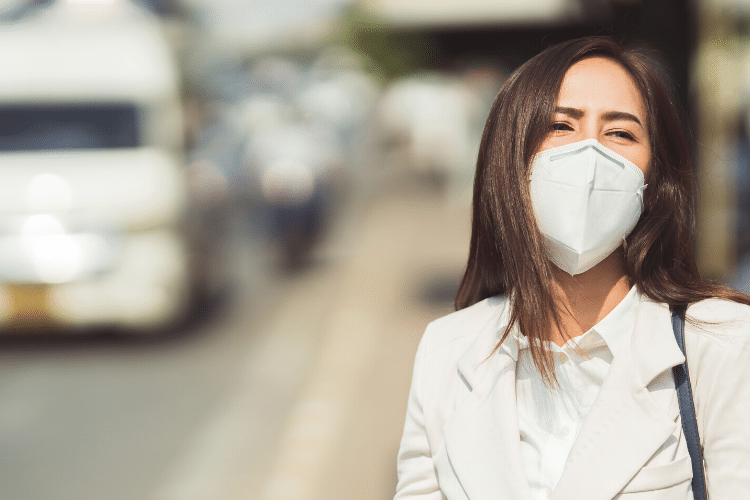 Woman wearing a mask outside on a sunny day